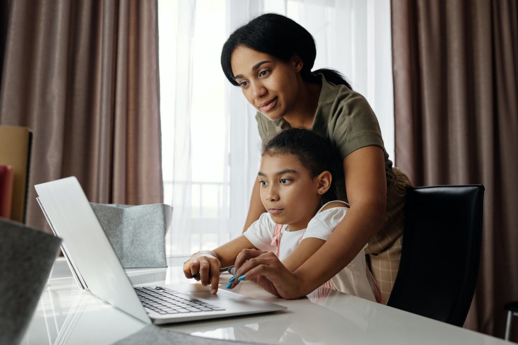 Une mère et sa fille regardent ensemble un ordinateur